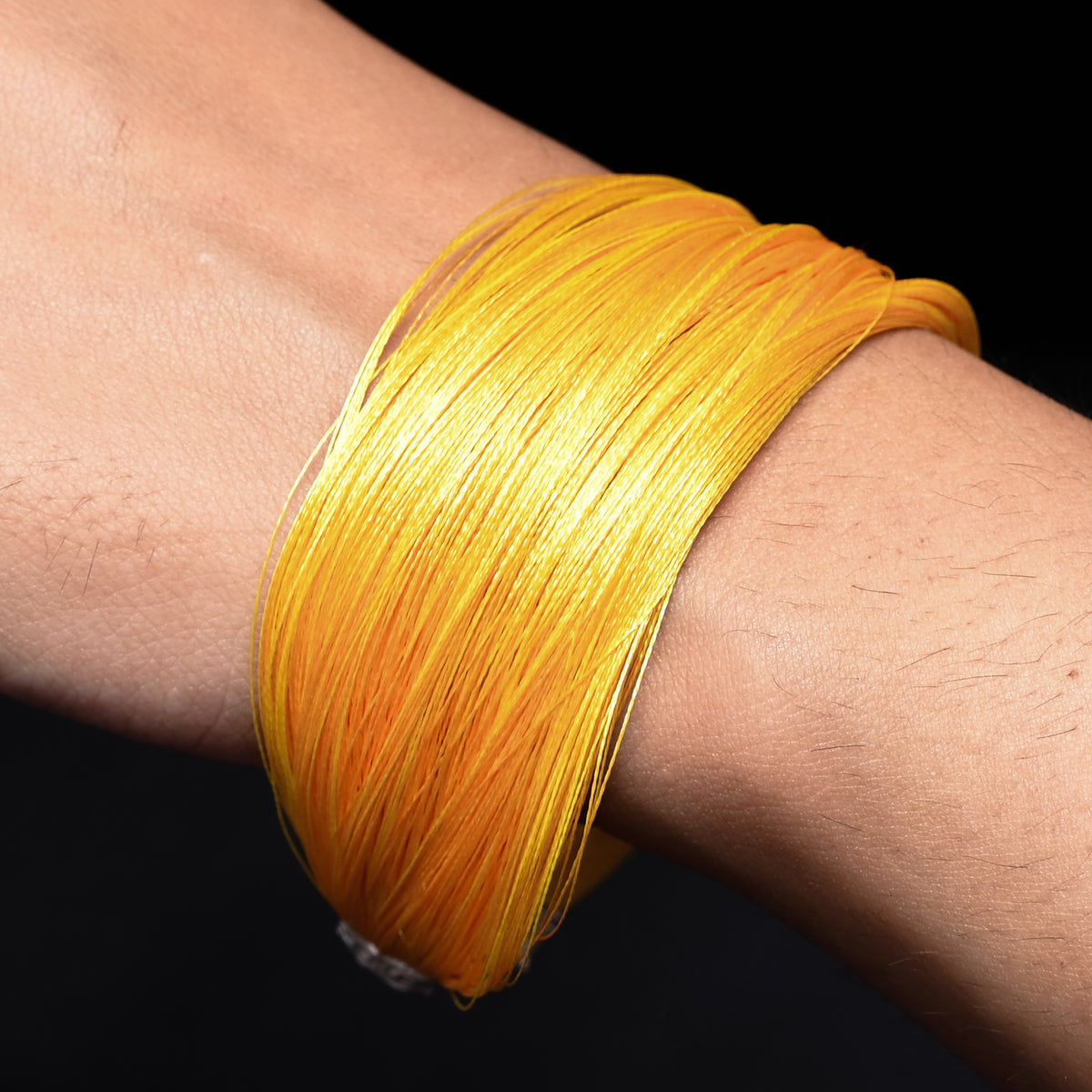 Chic silver moli bracelet with a striking yellow thread, perfect for adding a pop of color