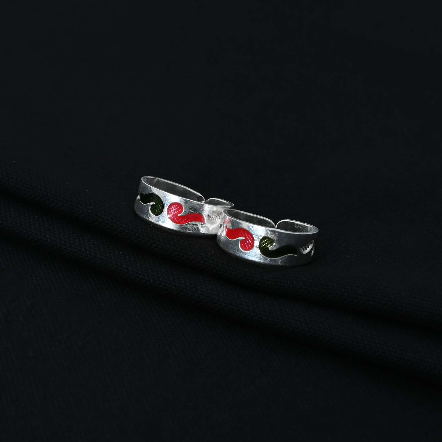 Stylish silver Bichhiya adorned with red and green stones in a flowing wind design, ideal for feminine wear
