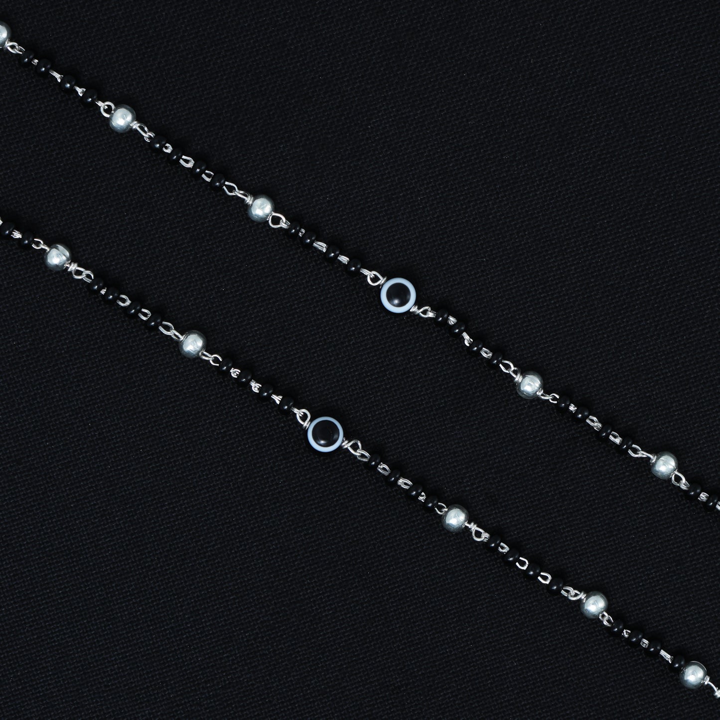 Elegant silver payal with black beads and a black evil eye symbol, perfect for modern style