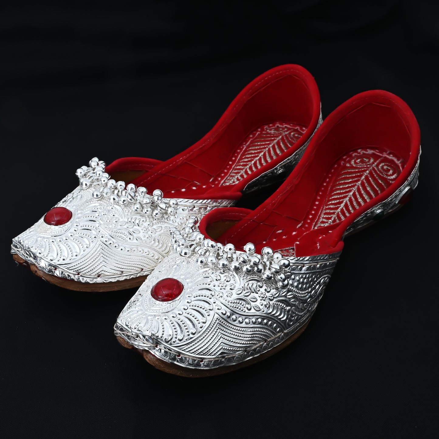 Elegant silver jutti with red stone and flower design