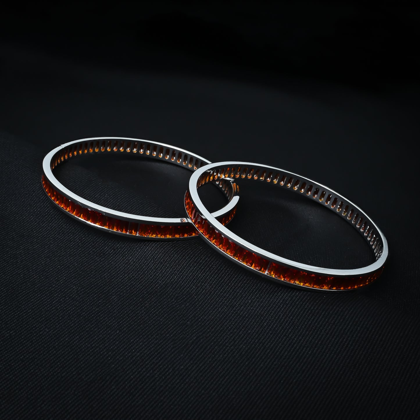 Charming silver bangles embellished with an array of orange stones