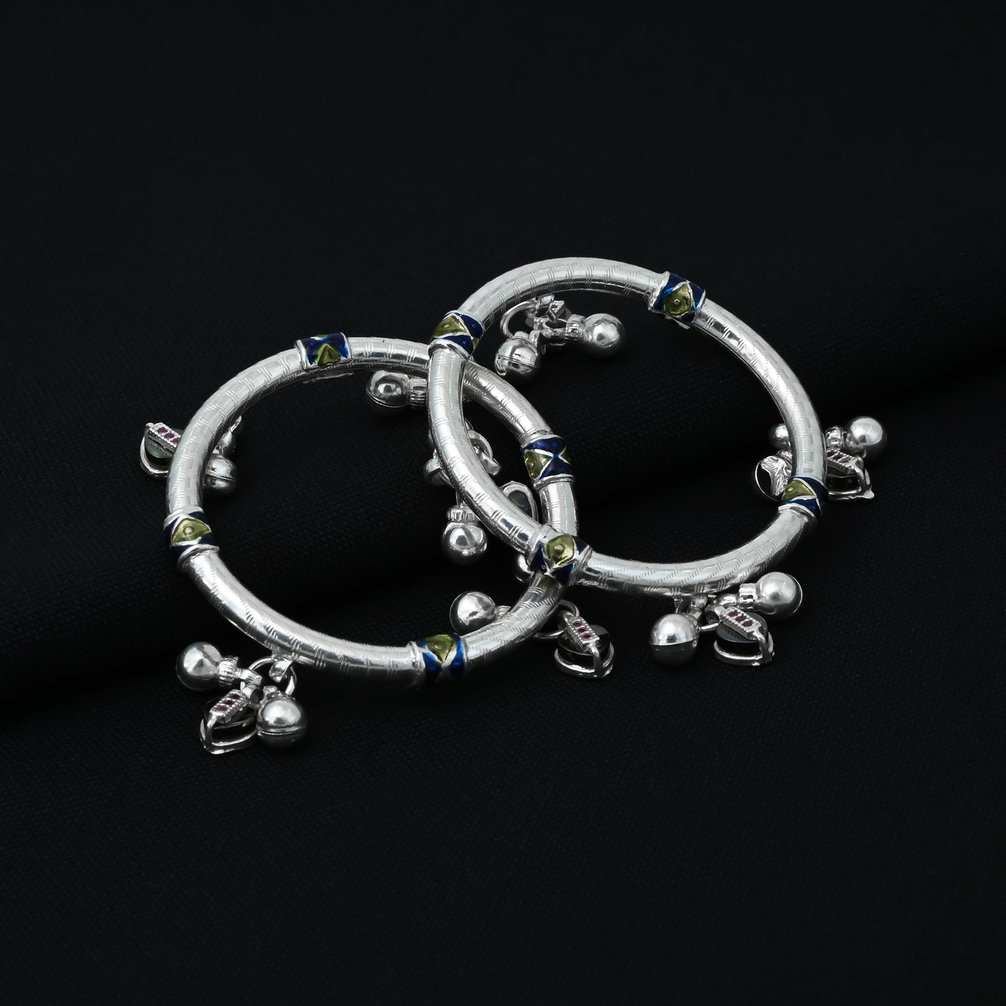 Silver kada payal for babies, adorned with a green heart shape and playful ghungroos.