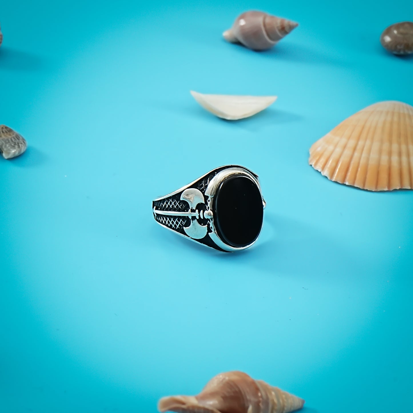 Stylish silver ring showcasing an oval black stone with a distinctive axe design for a modern touch.