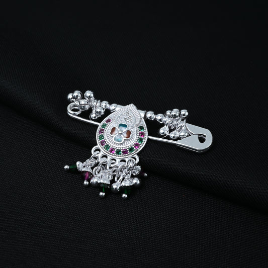 Elegant silver saree pin featuring a teardrop design with green and purple stones