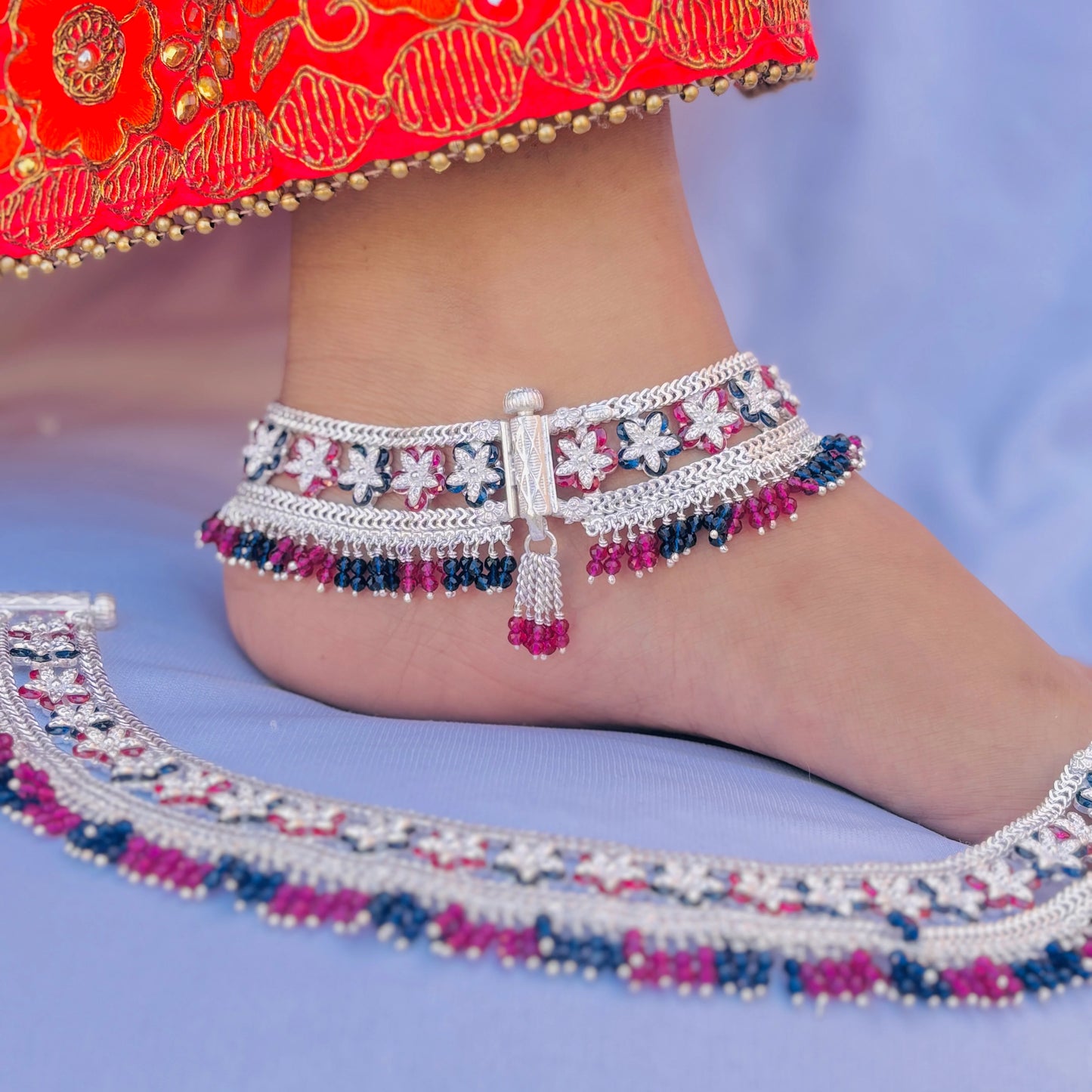 Sophisticated silver payal featuring purple and blue flowers, enhanced with bead detailing for a stylish touch