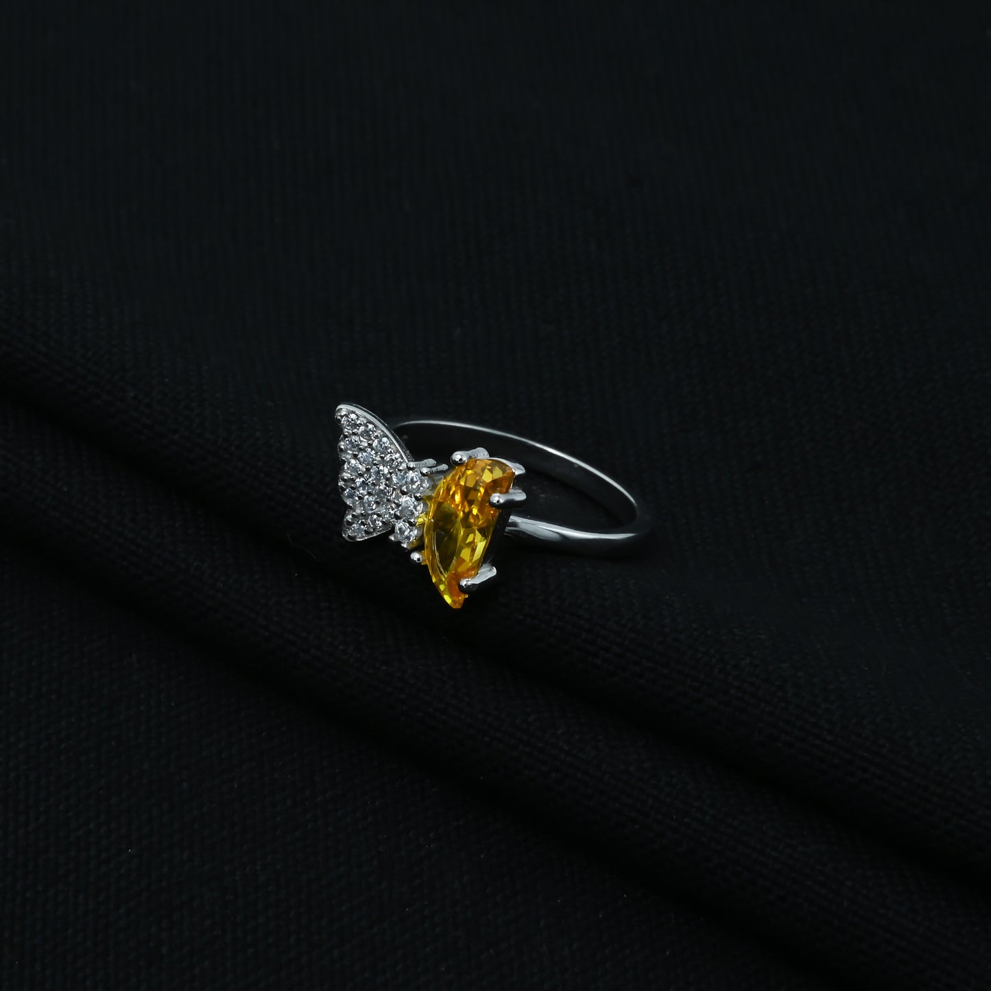 Silver ring adorned with a yellow stone in a butterfly design
