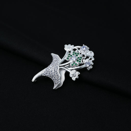 Elegant silver saree pin featuring a floral design with multiple green stones