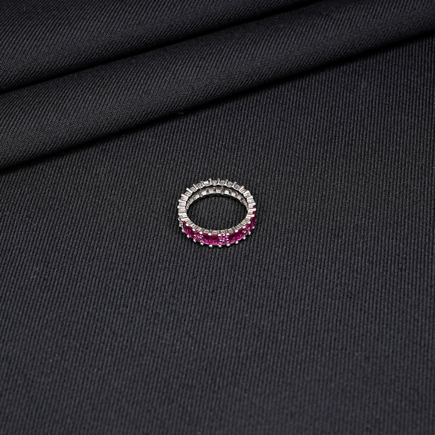 Silver ring adorned with a purple gemstone.