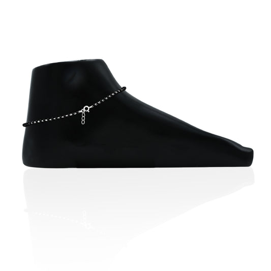 Elegant silver anklet adorned with vibrant green gems and sleek black beads