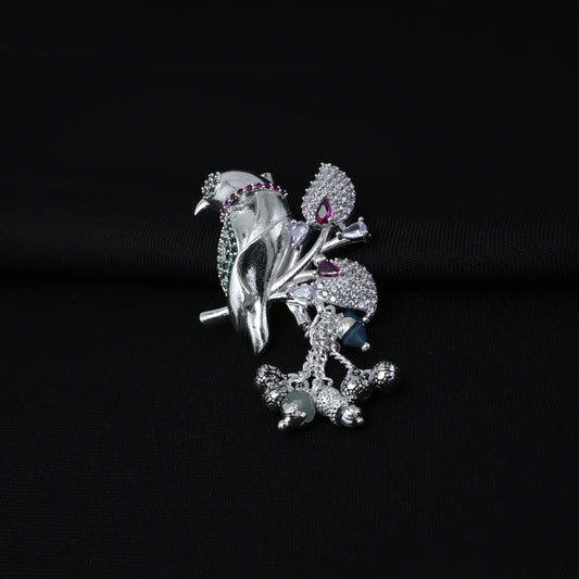 Elegant silver saree pin featuring a bird motif and green-purple stone accents