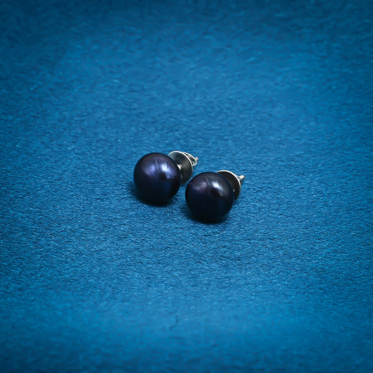 Chic royal blue pearl stud earrings with a silver finish