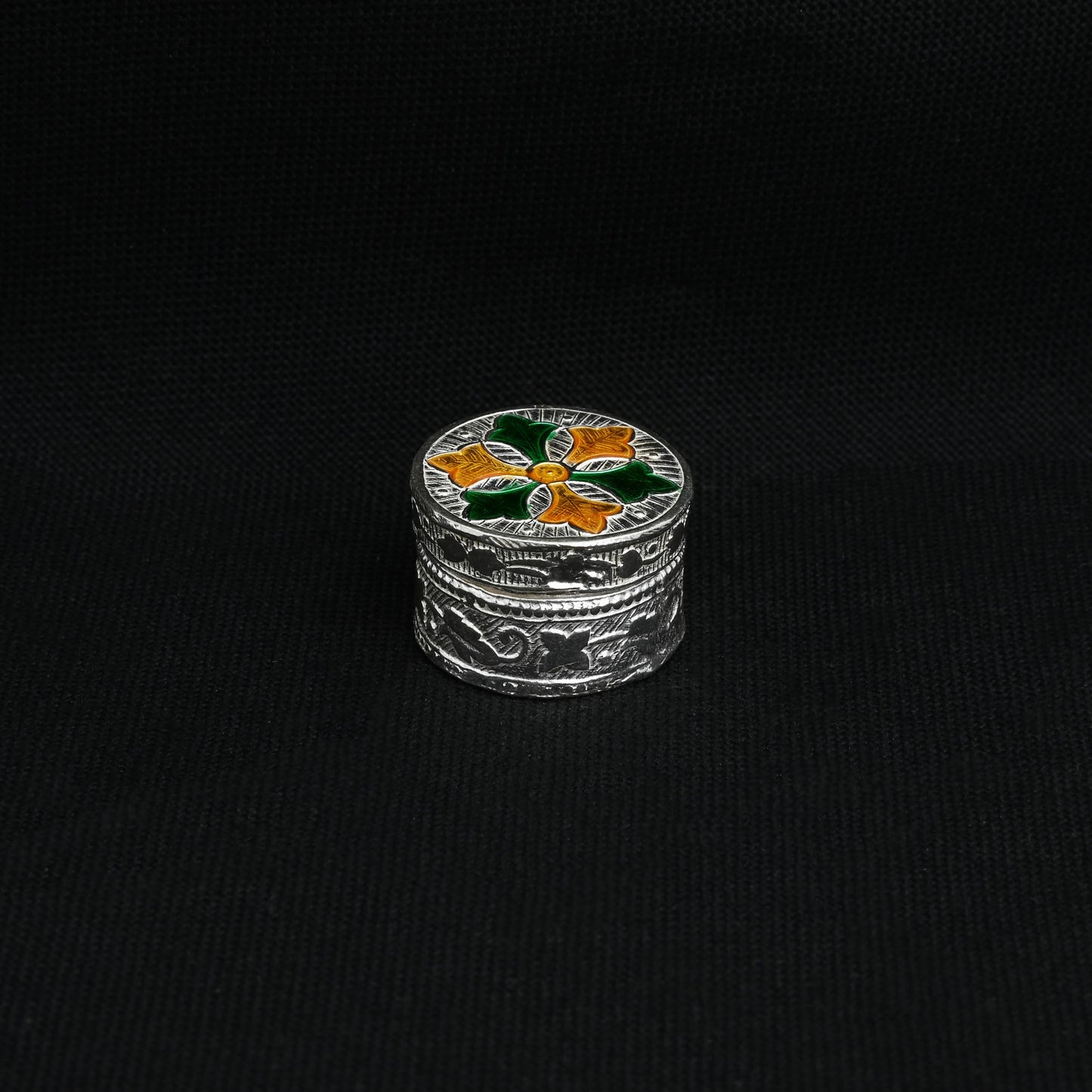 Handcrafted silver Sindoor box with a colorful design in a round shape