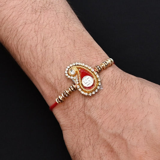 Elegant Rakhi with a silver Swasthik symbol, red theme, and a mix of colorful beads, ideal for boys.