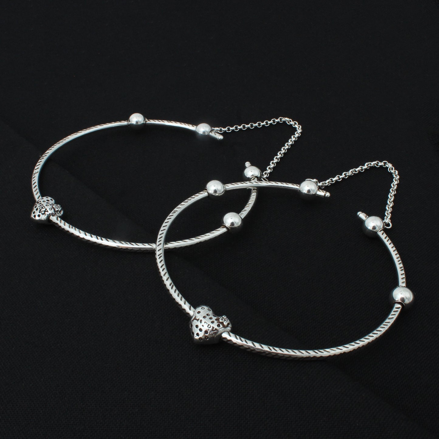 Fashionable silver kada payal adorned with stylish heart shape beads.