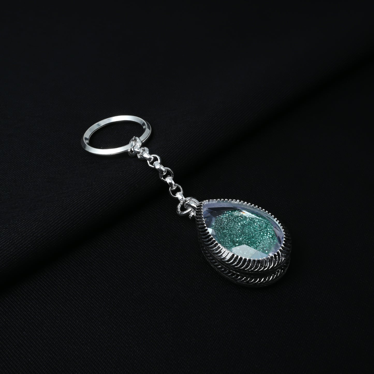 Trendy silver keychain adorned with a teardrop green gemstone for a unique touch