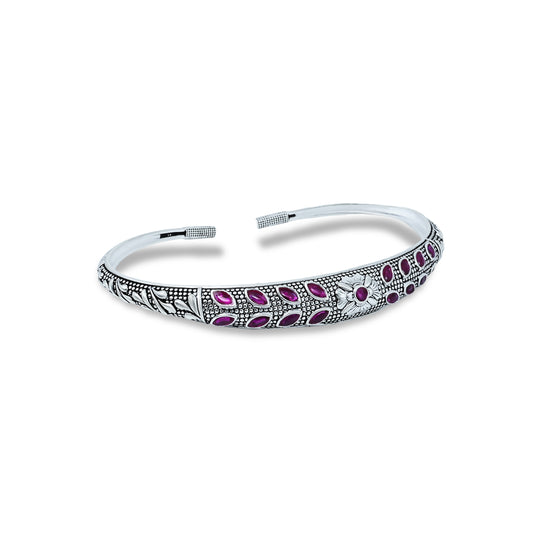 Elegant silver kada anklet featuring a central floral motif and purple stones.