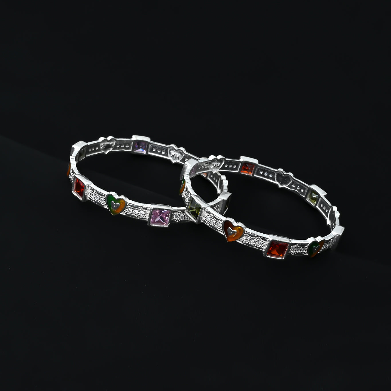 Stylish silver bangles with heart shapes and dazzling gemstones, designed to elevate your look with a timeless, romantic appeal