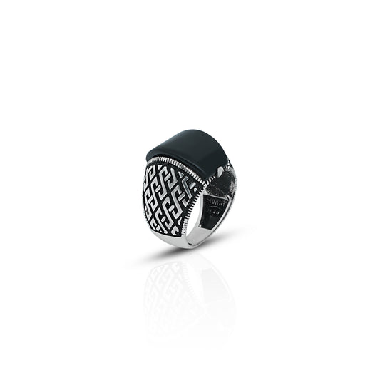 Close-up of a men's silver ring with a striking black onyx stone and intricate texture work