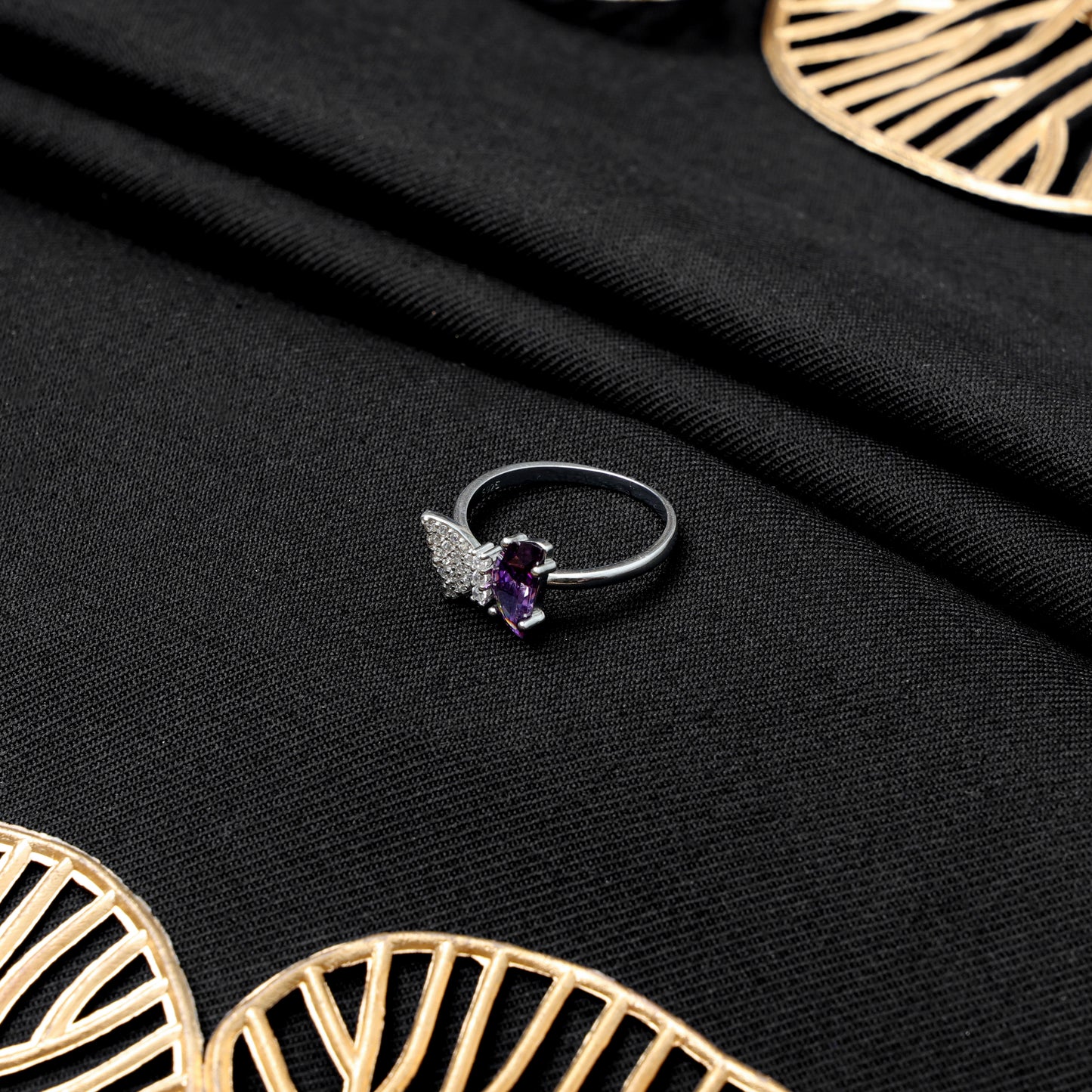 Butterfly design silver ring featuring purple gemstone.