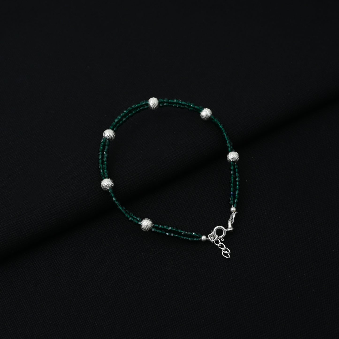 Trendy silver bracelet for boys adorned with green beads