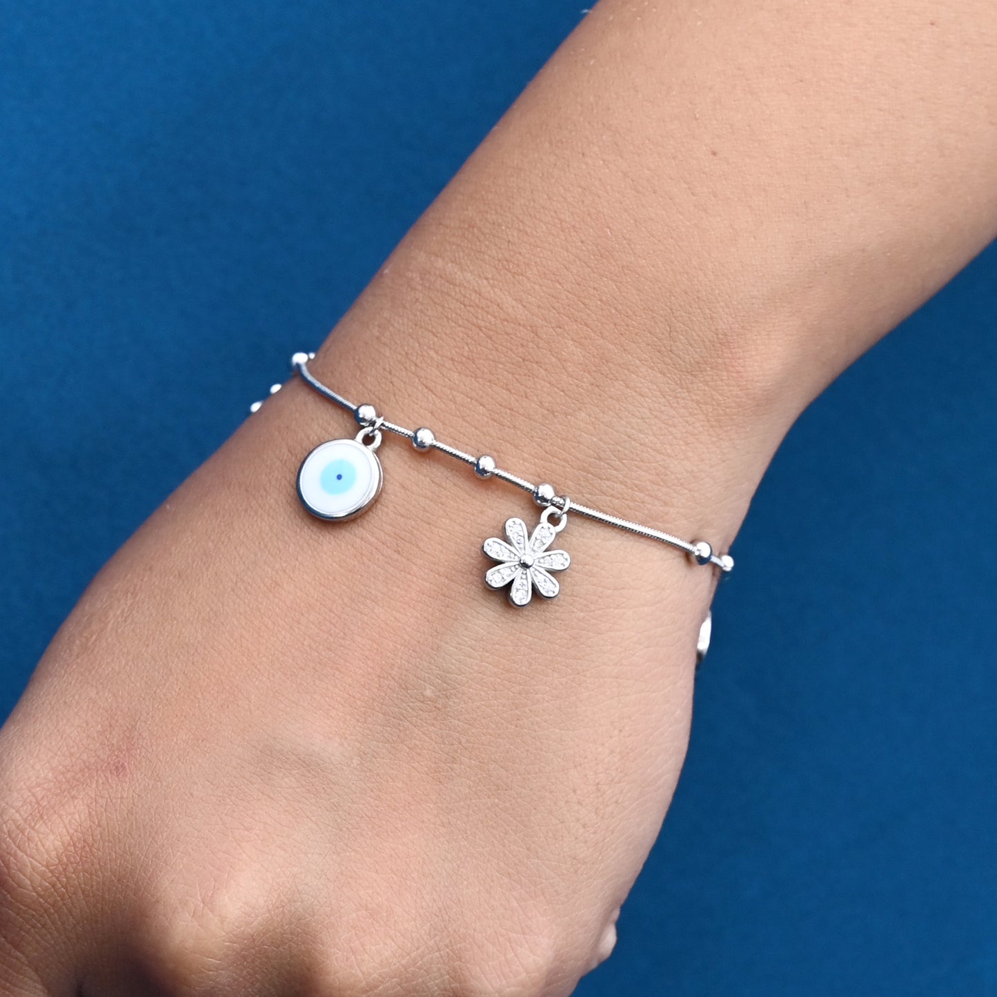 Stylish silver bracelet with a unique evil eye flower charm, promoting good luck and protection