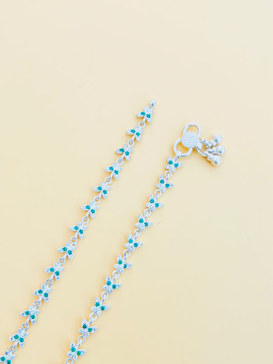 Elegant silver payal with a butterfly design and green gemstone accents.