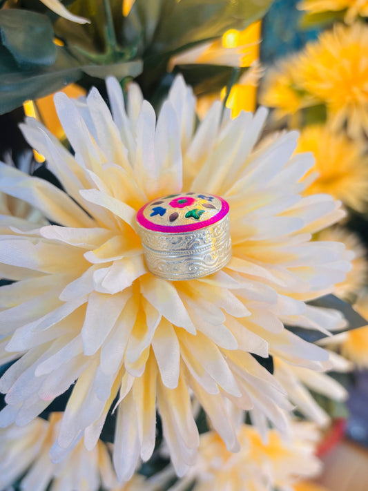 Elegant silver sindor box featuring a pink flower and vibrant multicolor leaves.