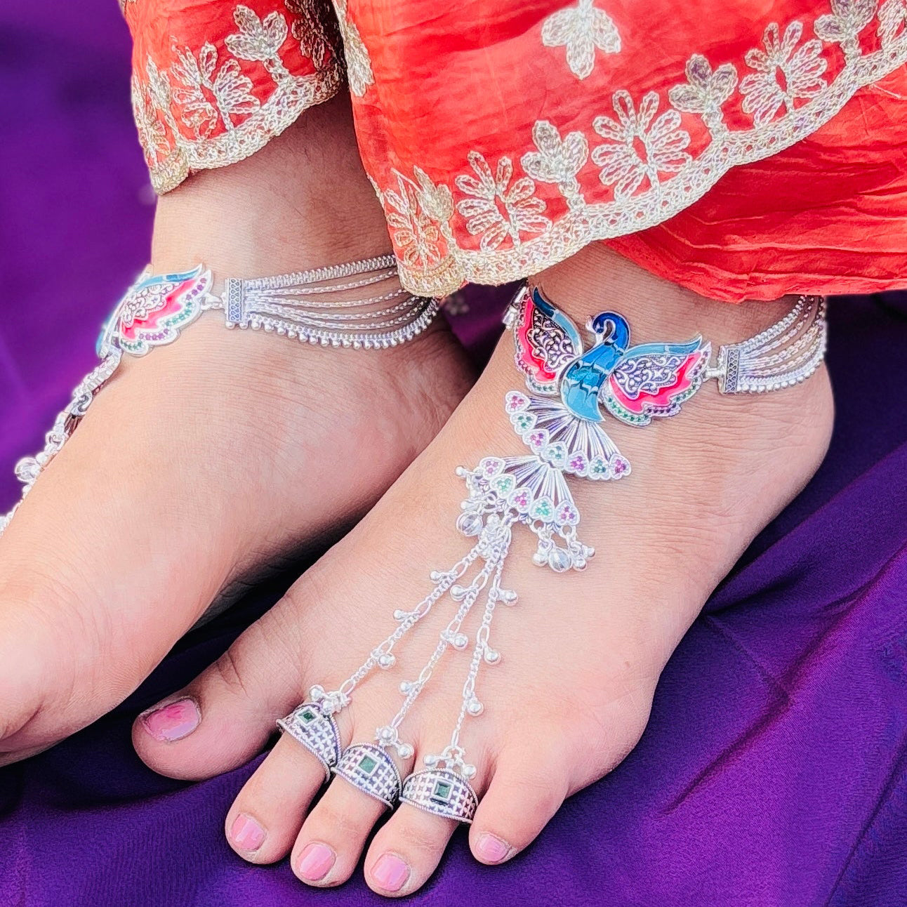 Silver payal with pag phool design and bold peacock center.