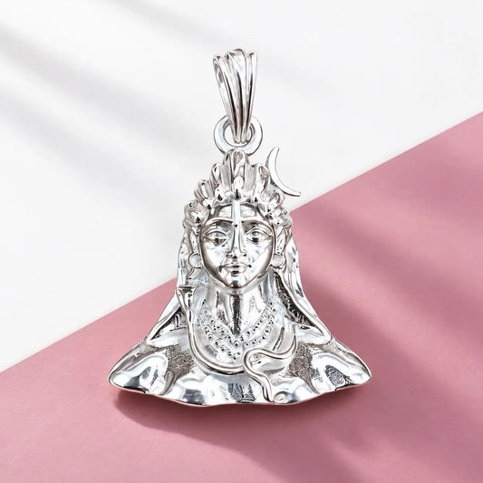 Silver Lord Shiva face pendant with crescent moon and detailed polished silver design on a warm beige background