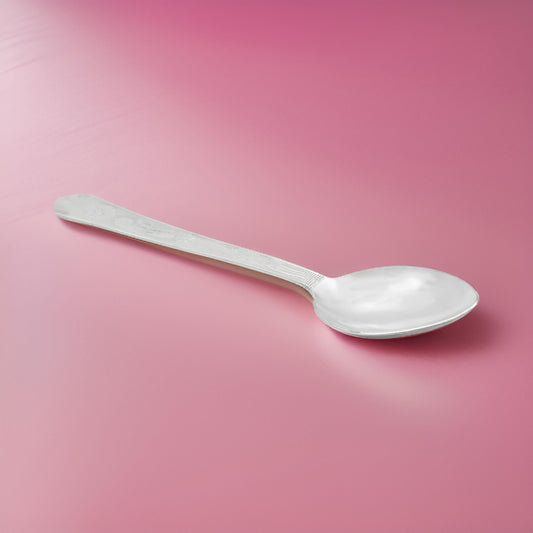 Intricate flower pattern on a handcrafted silver spoon