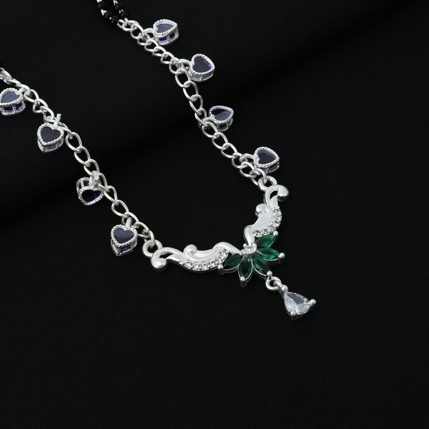 Beautiful silver mangalsutra adorned with purple and green stones and a unique wing design