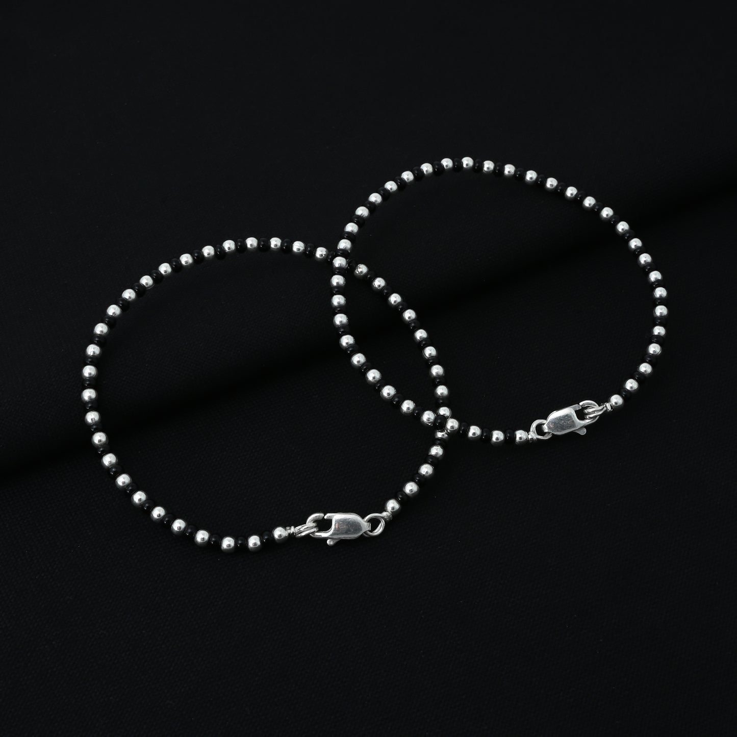 Silver anklet for girls adorned with black and silver beads, perfect for a trendy and sophisticated look.