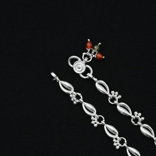 Elegant silver payal adorned with shell motifs and delicate ghungroo bells.