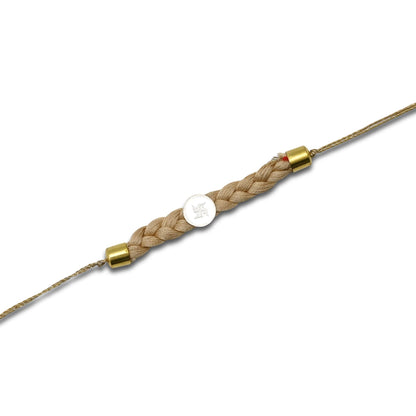 Boys' Rakhi featuring a silver Swastik centerpiece with a cream tangle Moli.