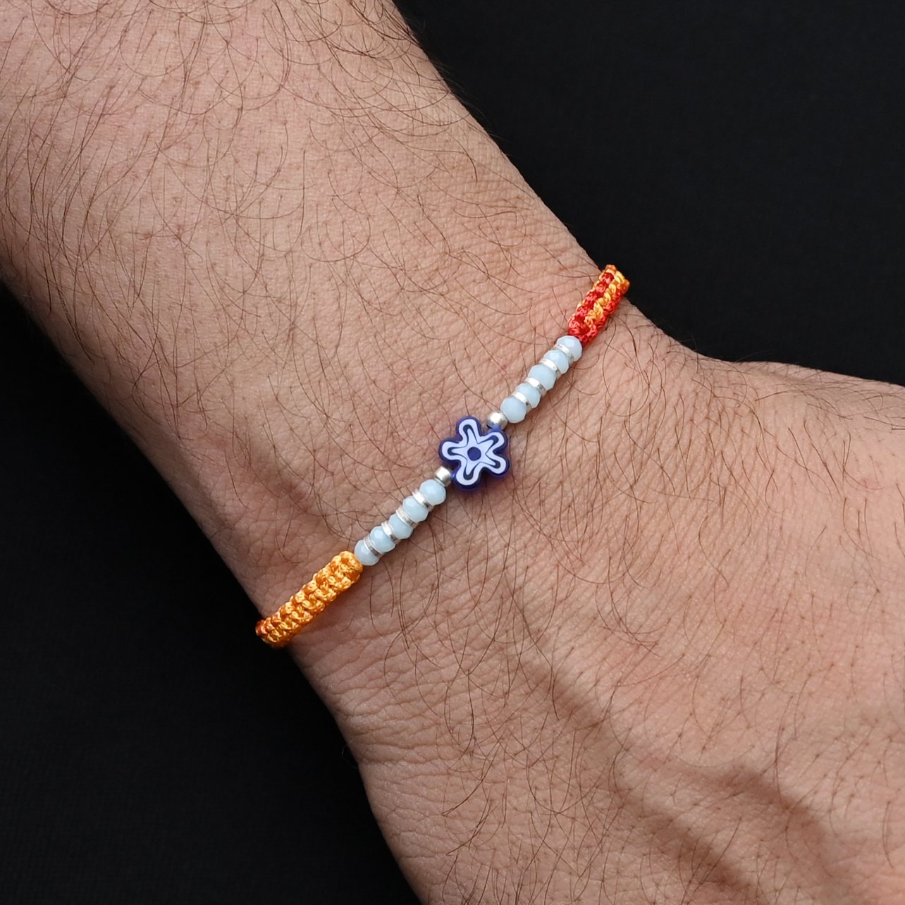 Elegant blue flower design in silver with light blue and silver beads, perfect Rakhi for boys