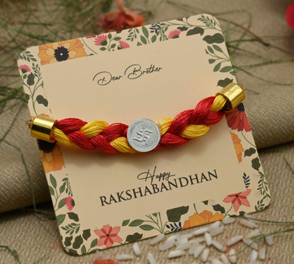 Silver center Swashtika design with red and yellow tangle Moli, perfect Rakhi for boys.