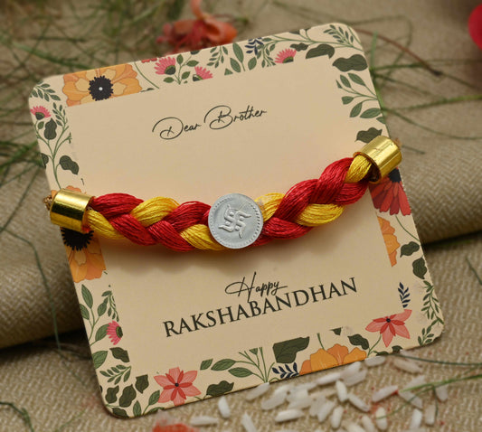 Silver center Swashtika design with red and yellow tangle Moli, perfect Rakhi for boys.
