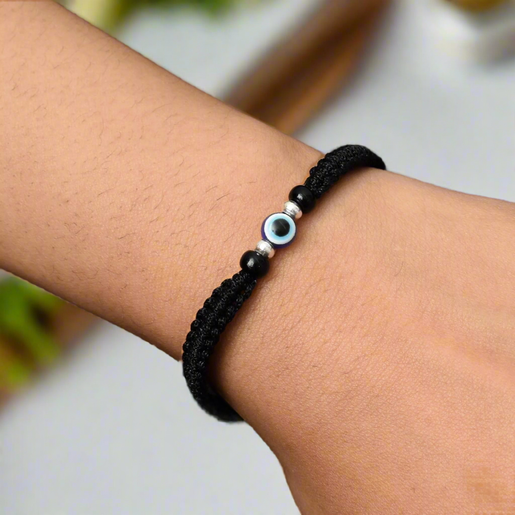 Adjustable silver dhaga bracelet featuring multiple evil eye charms for protection