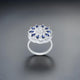 Elegant silver ring adorned with a big flower motif, accented by small blue stones