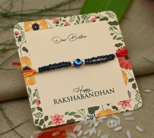 Silver center Evil Eye design with silver and blue beads Rakhi for boys.