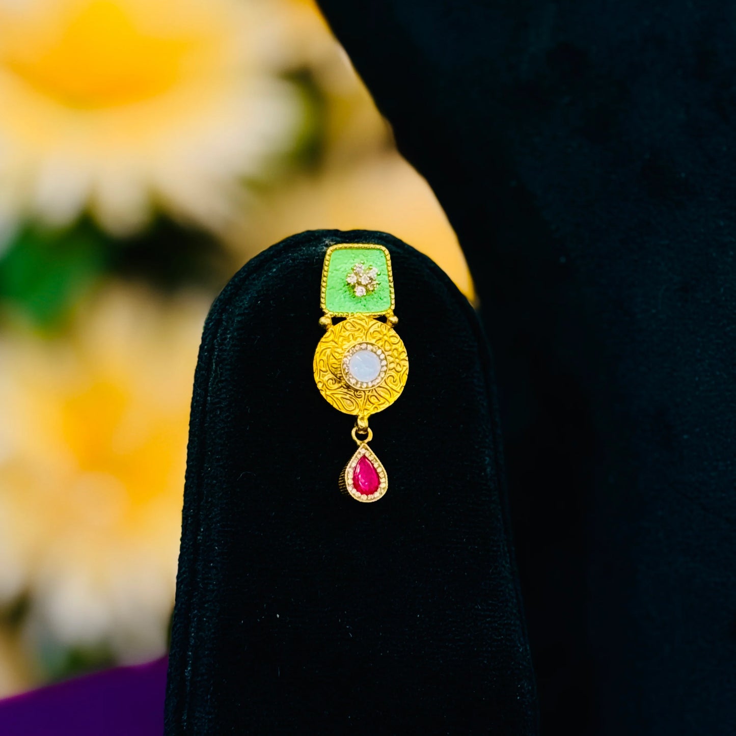 Elegant gold polish silver necklace featuring green buds and a bold red center stone.