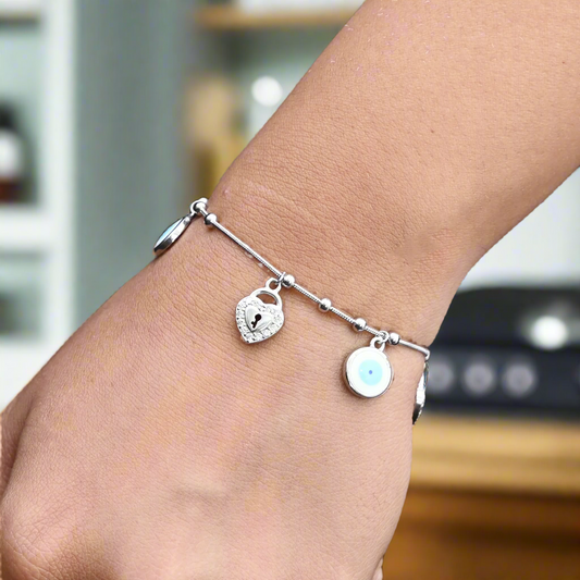 Sterling silver bracelet with a heart-shaped lock and evil eye charm for protection