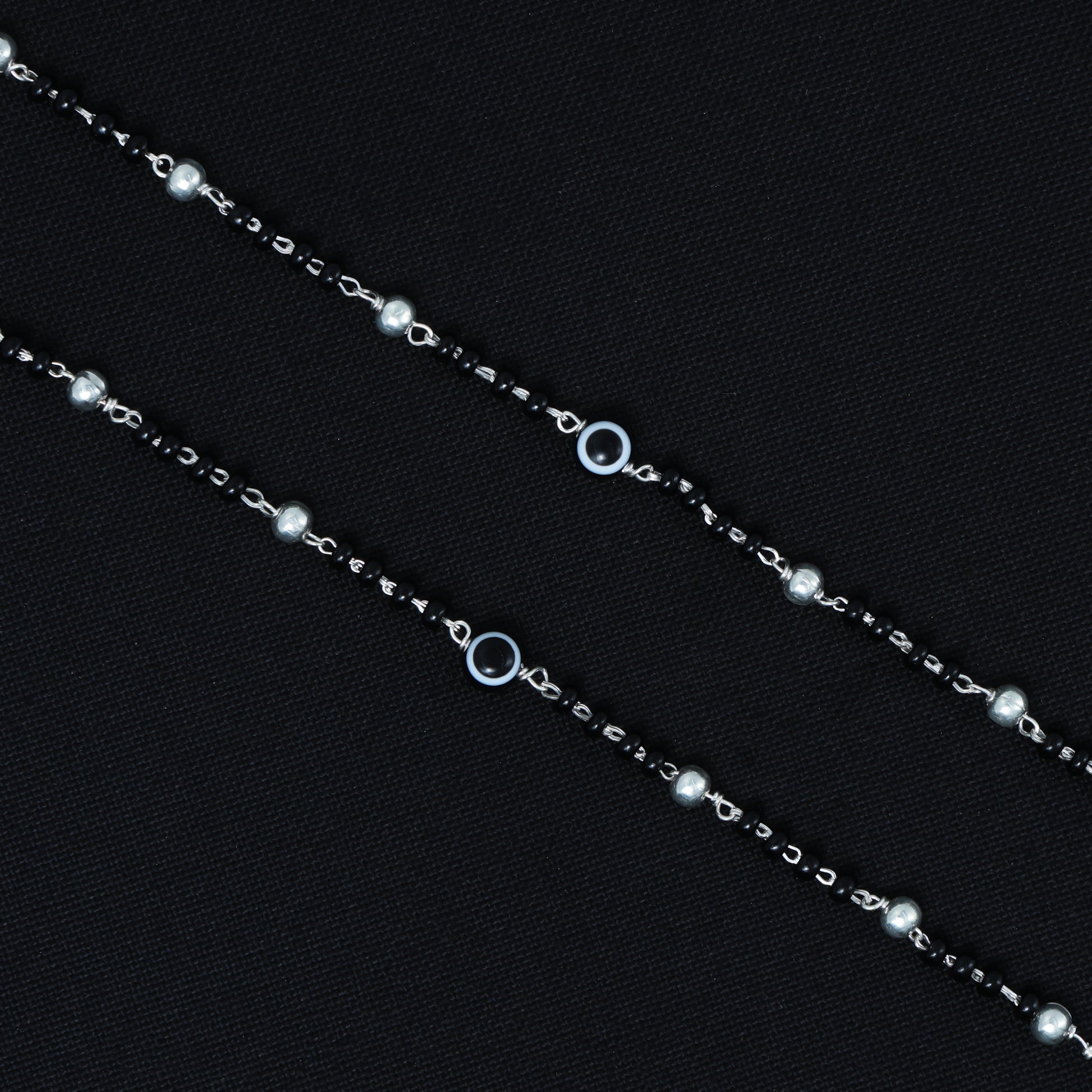 Elegant silver payal with black beads and a black evil eye symbol, perfect for modern style