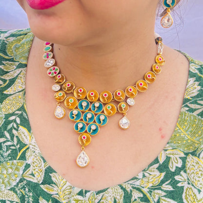 Stylish gold polish silver necklace featuring multicolor stones and blue centerpiece earrings.