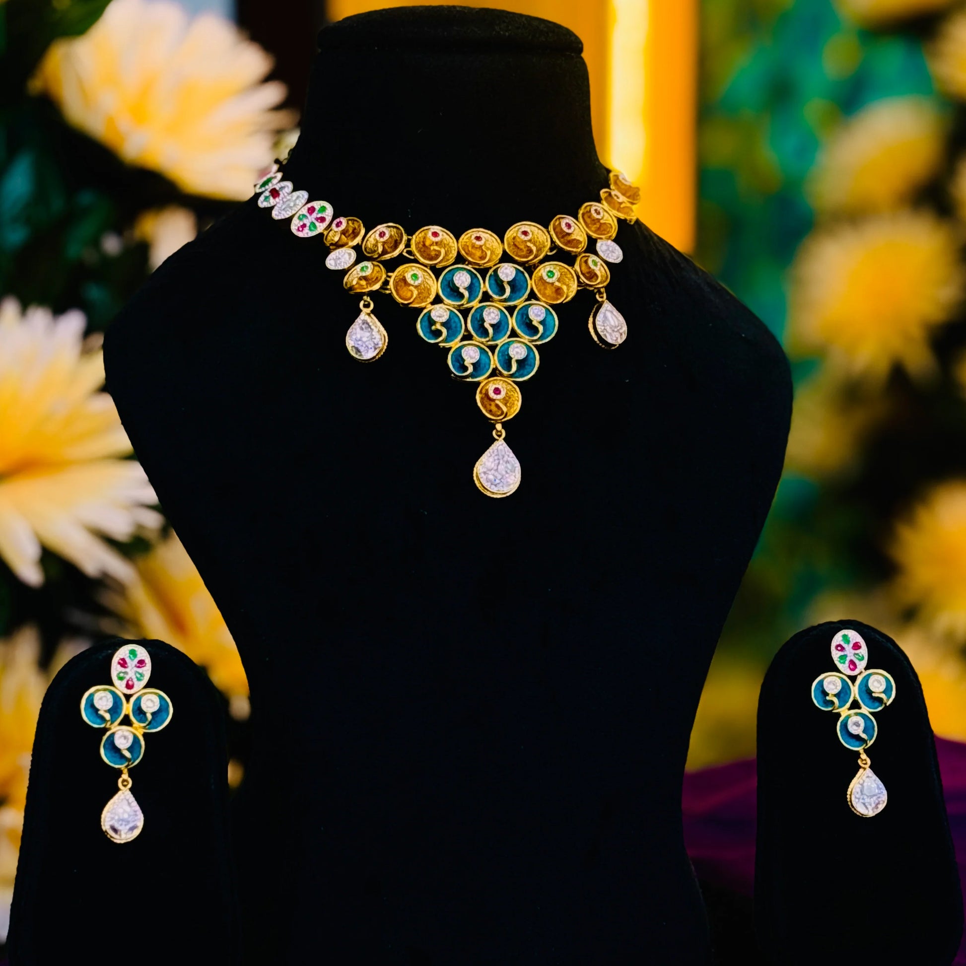 Elegant gold polish silver necklace with multicolor stones and blue centerpiece earrings.