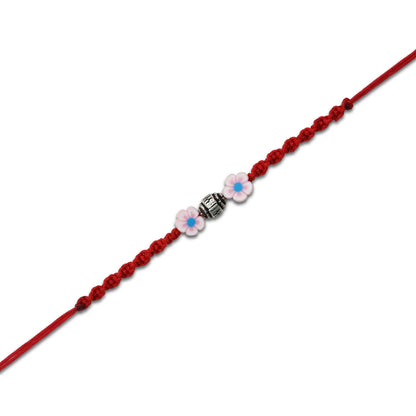 Boys' Rakhi featuring a silver bead centerpiece and soft pink flower accents.