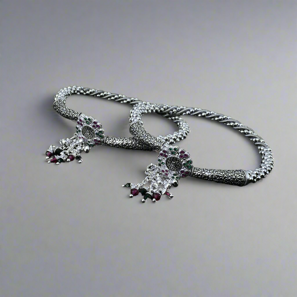 Silver anklet in kada style featuring a floral charm and jingling ghungroos