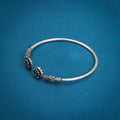 Stylish silver kada adorned with a flower design and a sleek titanium color