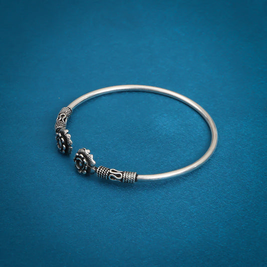 Stylish silver kada adorned with a flower design and a sleek titanium color