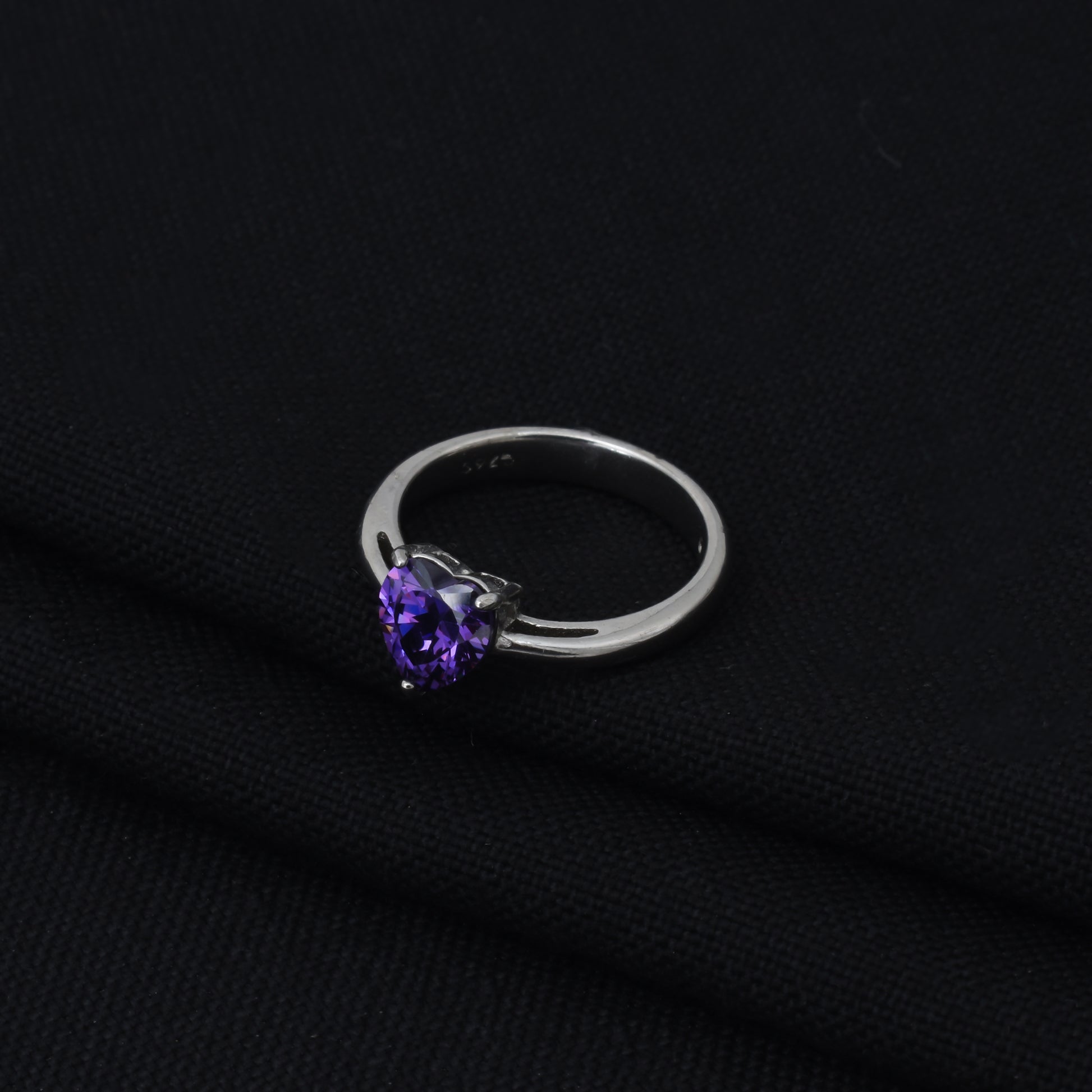 Beautiful silver ring featuring purple heart-shaped stone.